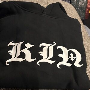 K I N Black Hoodie with White Gothic logo lettering
